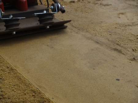 Увлажненный песок после прохождения виброплитой